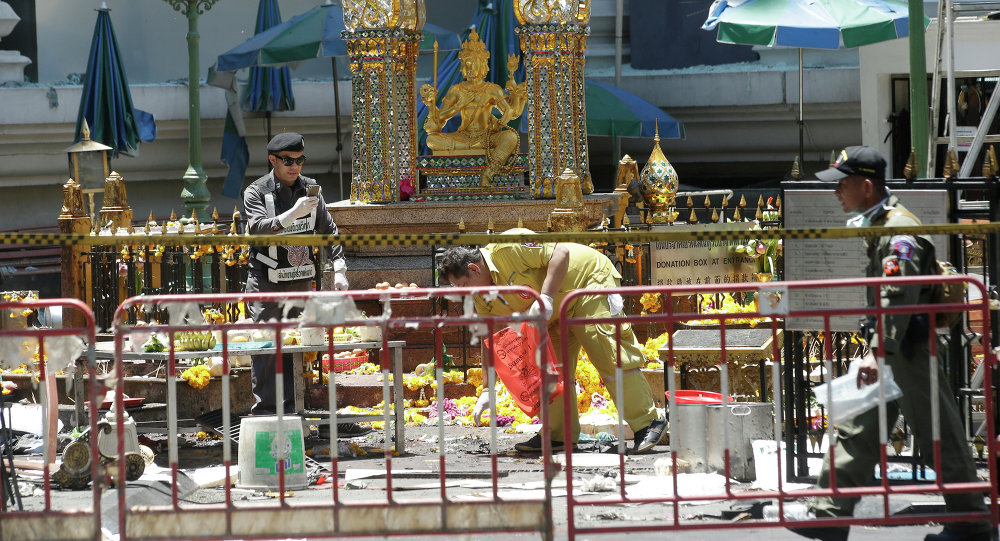 Police and officials work near the statue of Phra Phrom the Thai interpretation of the Hindu god Brahma at the Erawan Shrine at Rajprasong intersection the day after an explosion in Bangkok Thailand Tuesday Aug. 18 2015