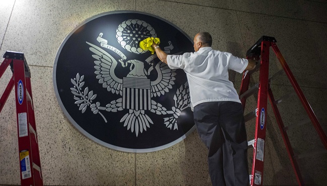 A worker wipes a representation of the The Great Seal of the United States at the newly opened U.S. Embassy in Havana Cuba Friday Aug. 14 2015. U.S. Secretary of State John Kerry arrived Friday morning in Havana for an historic ceremony to raise the U