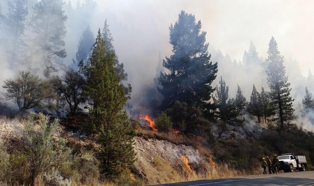 The Canyon Creek complex fire burns along the path of U.S. Highway 395 south of John Day Ore. on Tuesday