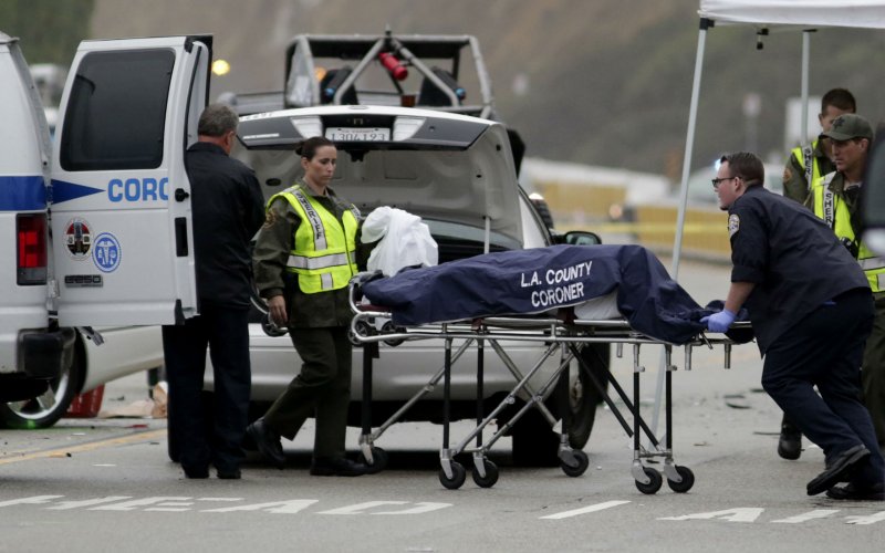 A Los Angeles County coroner worker loads a victim into a van at the scene of a four-car crash involving Olympic gold medalist and reality TV star Bruce Jenner in Malibu California