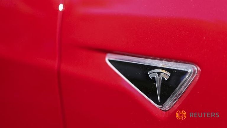 The Tesla logo is seen on a Tesla Model S P85D outside the company's headquarters in Palo Alto California