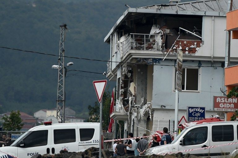 People stand outside the police station in the Sultanbeyli district in Istanbul after a suspected suicide bomber detonated a vehicle packed with explosives at the police station. – AFP pic