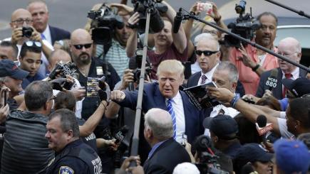 Donald Trump gives a fist bump to a pedestrian as he arrives for jury duty in New York