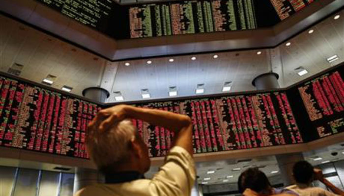 People watch trading boards at a private stock market in Kuala Lumpur Malaysia on Monday Aug. 24 2015. Stocks tumbled across Asia on Monday as investors shaken by the sell-off last week on Wall Street unloaded shares in practically every sector