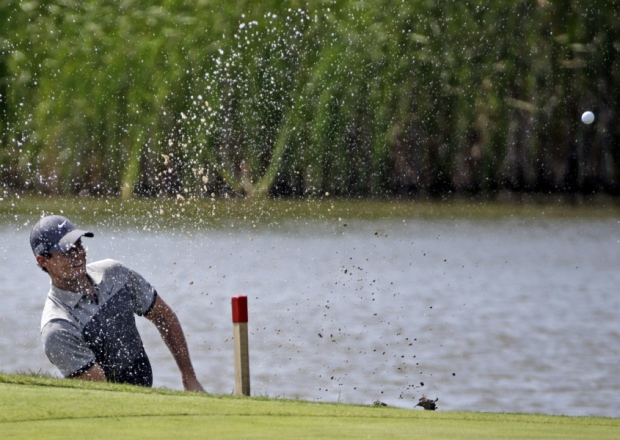 Rory Mc Ilroy hits out of some water on the fifth hole