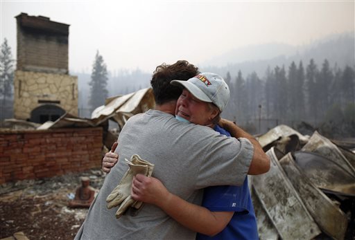 Cindy Aston hugs her neighbor Todd Quinn after she lost her childhood home in the neighborhood of Antoine Creek outside of Chelan Wash. from the firestorm on Saturday Aug. 15 2015