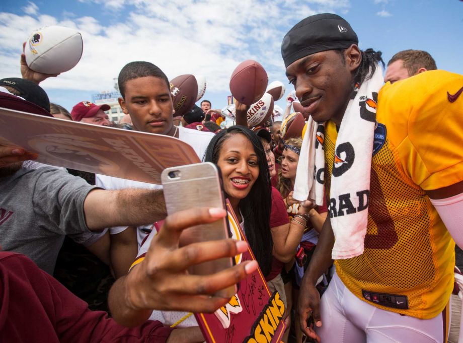 Washington quarterback Robert Griffin III makes time for adoring fans Saturday at Redskins training camp in Richmond Va