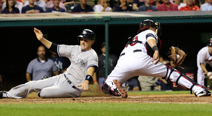 New York Yankees Stephen Drew scores on a single by Brad Gardner next to Cleveland Indians catcher Yan Gomes during the sixth inning of a baseball game Thursday Aug. 13 2015 in Cleveland