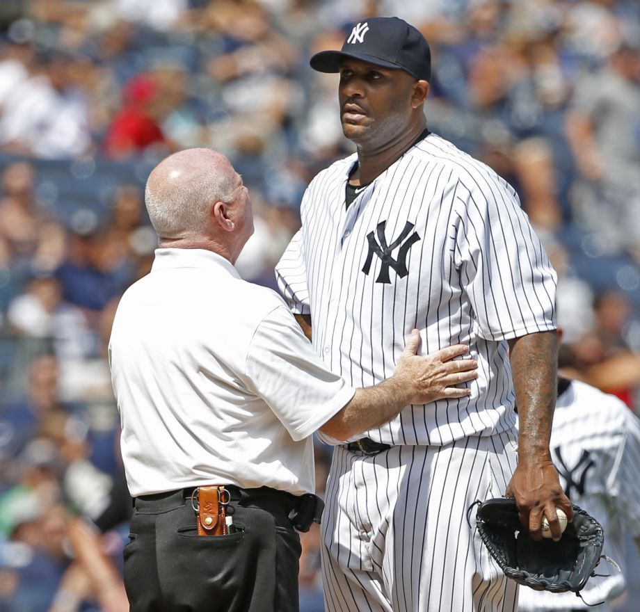 New York Yankees trainer Steve Donohue left talks to New York Yankees starting pitcher CC Sabathia on the mound in the third inning before New York Yankees manager Joe Girardi removed Sabathia from the baseball game against the Cleveland Indians at Yank