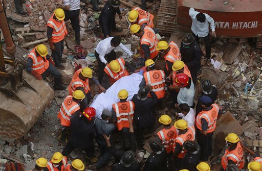 Rescue workers carry the body of a victim at the site of building collapse in Thane outskirts of Mumbai India Tuesday Aug. 4 2015. According to an official the building was more than 50 years old and had been damaged by the rain