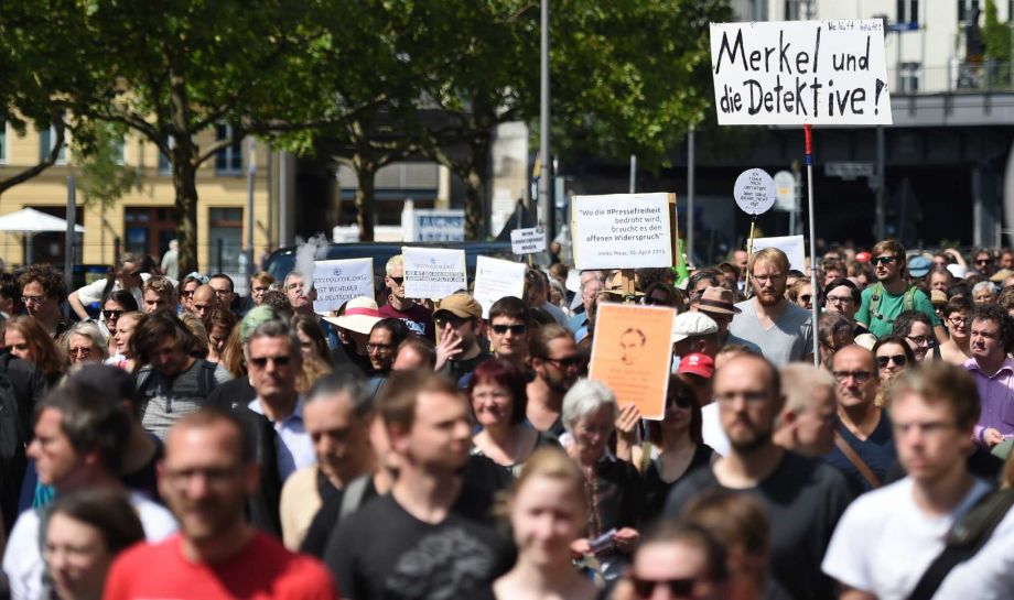 Participants of a demonstration protest in Berlin Saturday Aug. 1 2015. Banner at right reads'Merkel und die Detektive! . Some 1,300 people rallied in Berlin for the freedom of the press in support of two journalists