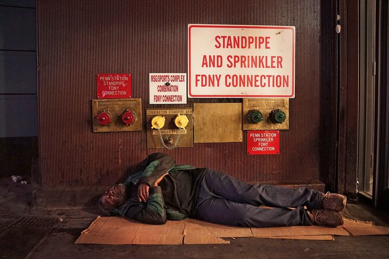 A homeless man sleeps on a Manhattan street