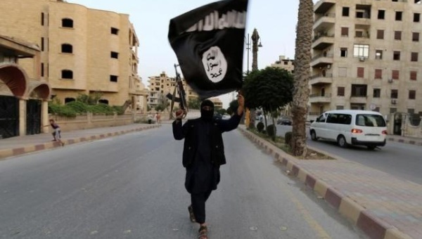 A member loyal to the Islamic State in Iraq and the Levant waves an ISIL flag in Raqqa
