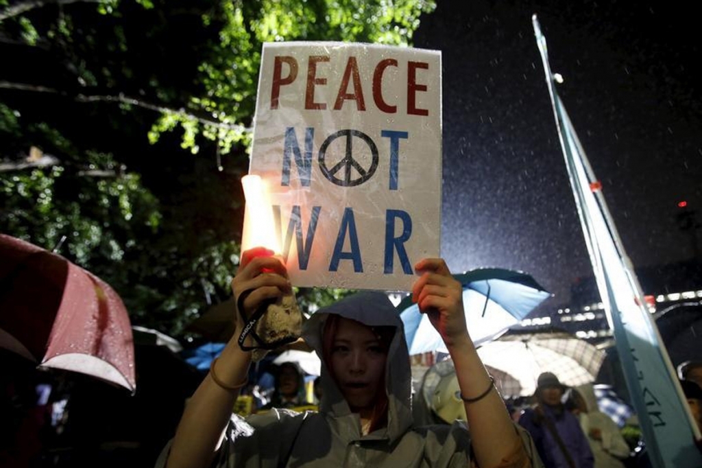 A protester holding a placard takes part in a rally against Shinzo Abe's security bill