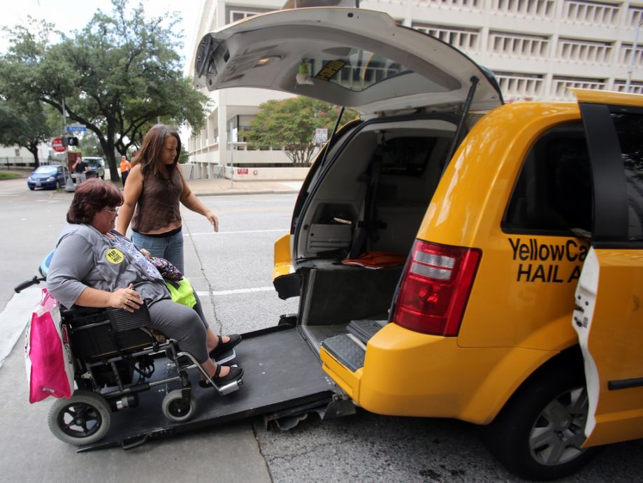 Taxi driver Crystal Gardner helps Lara Posadas board a taxi in front of Houston City Hall on Aug. 6 2014. The taxi industry has argued throughout Uber's entrance into Houston that handicap riders will not benefit from new services because they are not