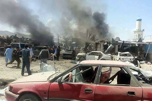 Afghan security forces and civilians walk at the site of a suicide attack in the Urgun area of Paktika province Afghanistan Tuesday