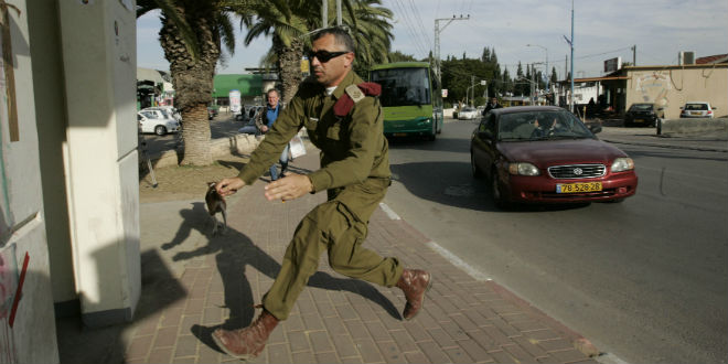 An IDF soldier runs into a bomb shelter during a Code Red alarm warning of an incoming rocket