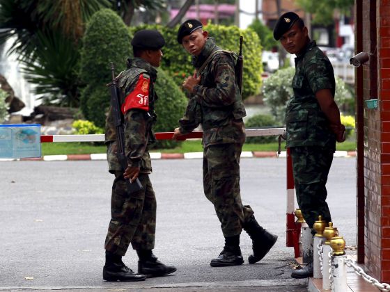 Thai Army officers stand guard at a gate of the military barracks believed to be holding two arrested bomb suspects involved in the recent Bangkok blast in Bangkok