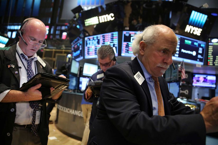 Traders work on the floor of the New York Stock Exchange on Friday. A day after the Federal Reserve decided not to raise interest rates stocks plunged with the Dow dropping nearly 290 points by the close