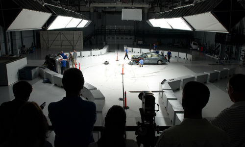 People on the observation deck watch as engineers inspect a car after a crash test at the Vehicle Research Center. The VRC was the site of today's announcement regarding automatic emergency braking