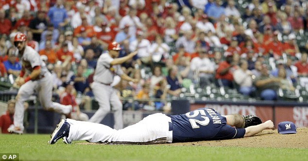 Struck Milwaukee Brewers starting pitcher Jimmy Nelson lays on the ground after being hit in the head by a ball hit by St. Louis Cardinals Thomas Pham during the third inning of a baseball game on Thursday