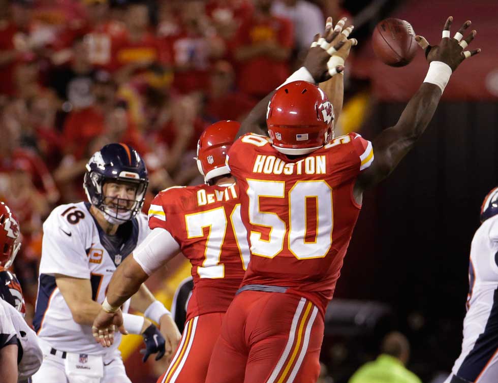 Denver Broncos quarterback Peyton Manning throws under pressure from Kansas City Chiefs defensive lineman Mike De Vito and linebacker Justin Houston