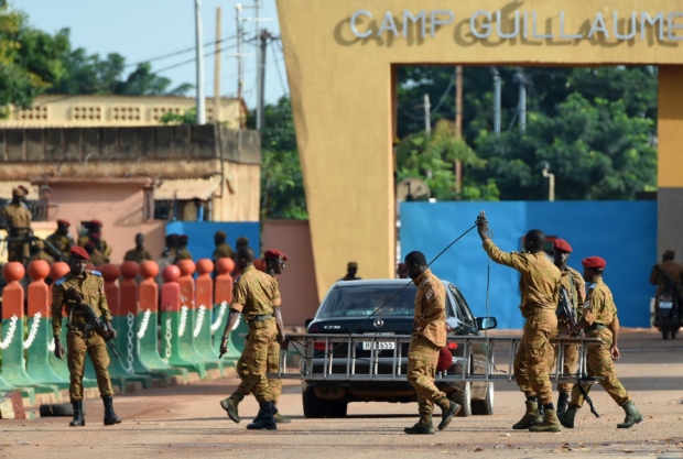 Burkina Faso army troops stand guard outside Guillaume Ouedraogo military camp in the capital Ouagadougou yesterday