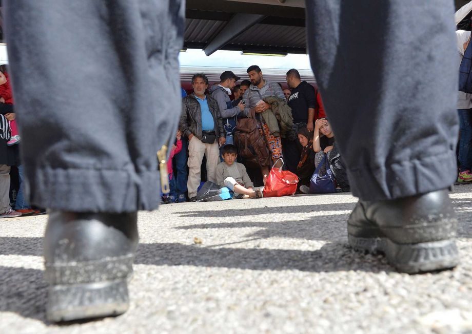 Refugees rest at the railway station after police stopped their train coming from Austria in Freilassing southern Germany Tuesday Sept. 15 2015. Germany introduced temporary border controls Sunday to stem the tide of thousands of refugees streaming