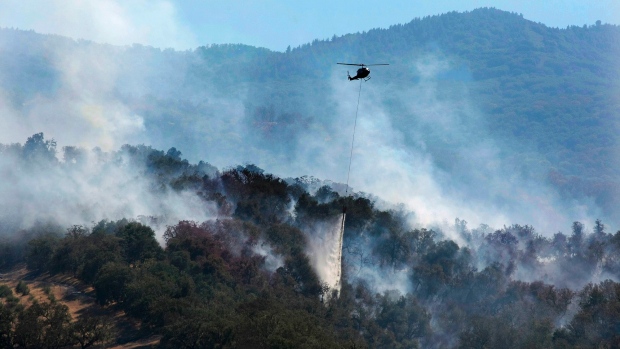 A helicopter makes a water drop on a wildfire hot spot Sunday in Carmel Valley Calif. The blaze burning north of the community of Jamesburg quickly grew after starting Saturday afternoon the California Department of Forestry and Fire Protection said