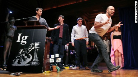 Bruno Grossi a researcher from Chile shows how a chicken would walk like a dinosaur with a weighted stick attached to its tail while being honored with an Ig Nobel Prize on Thursday