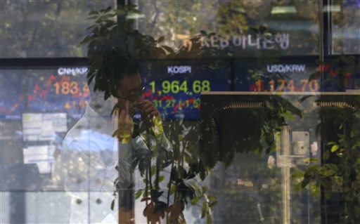 A currency trader talks on the phone near the screen showing the Korea Composite Stock Price Index at the foreign exchange dealing room in Seoul South Korea Monday Sept. 21 2015. Asian stock markets were mostly lower Monday after concerns abou