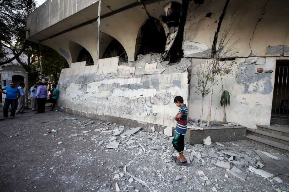 A boy walks around the site of an explosion as Egypt's security forces investigate the incident that damaged a nearby building with administrative offices for Egypt's Ministry of Foreign Affairs in Cairo Egypt Sunday Sept. 20 2015. Egypt's state news