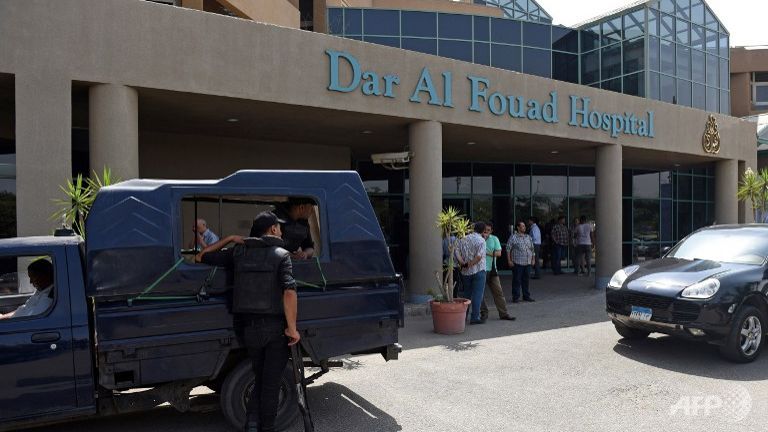 Egyptian security members stand guard outside the Dar al Fouad Hospital in a western Cairo suburb