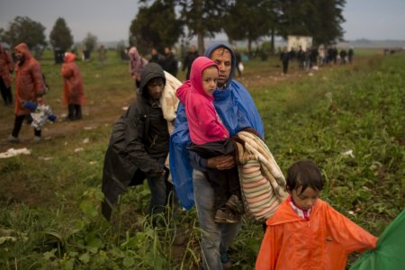 Migrants walk on a field after they crossed the border with Serbia near Tovarnik Croatia