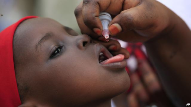FILE- A health official administers a polio vaccine to a child in Kawo Kano Nigeria April. 13 2014