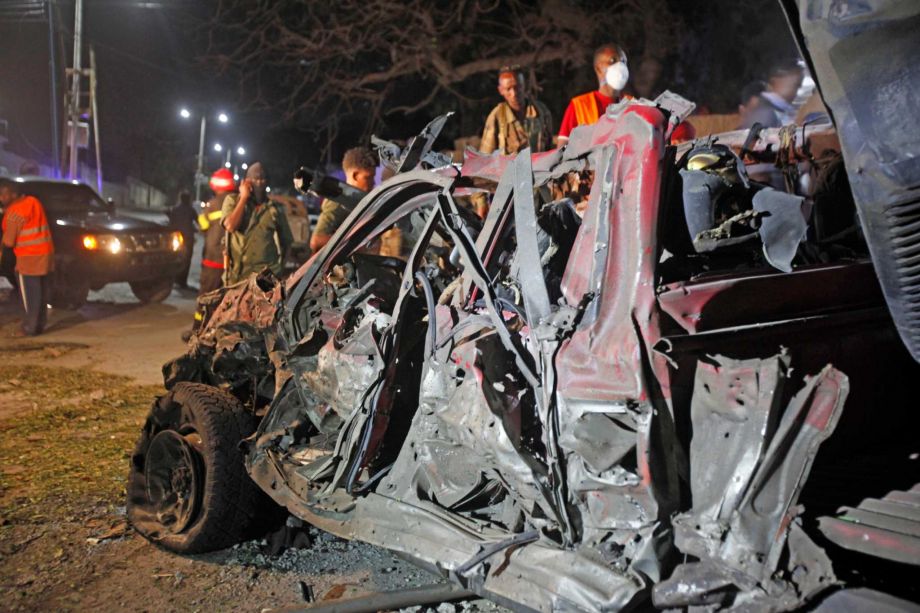 Soldiers stand near the wreckage of a suicide car bomb outside Somalia's presidential palace Monday Sept 21 2015. An Islamic extremist suicide bomber detonated an explosives-laden vehicle at the gate of the Somalia's presidential palace in the capital