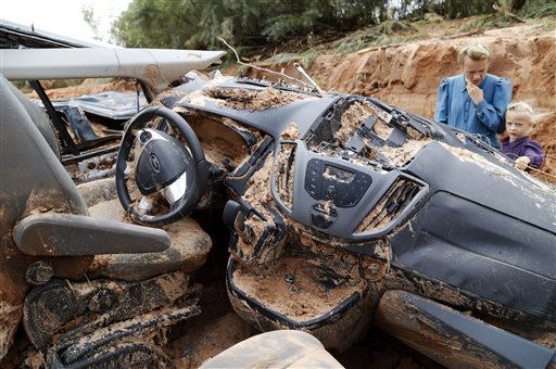 A woman and child examine a vehicle swept away during a flash flood Tuesday Sept. 15 2015 in Hilldale Utah. Authorities say several people have died in flash flooding that swept away vehicles on the Utah Arizona border. (Michael Chow  The Arizona Repu