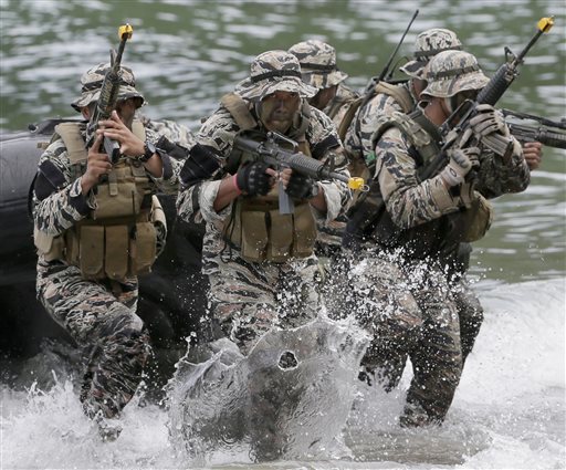 Philippine Marines from the Naval Special Operations Group storm the beach to simulate an'extraction of a kidnapped victim as they kick off a five-day amphibious military exercise at the Philippine Marines training center in Ternate Cavite pro