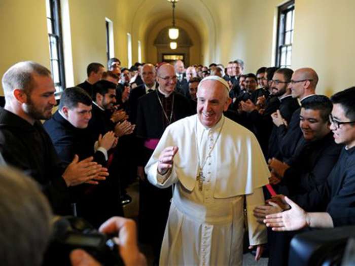 FILE- Pope Francis greets seminarians as he walks the loggia to his address to the Bishops at St. Martin of Tours Chapel