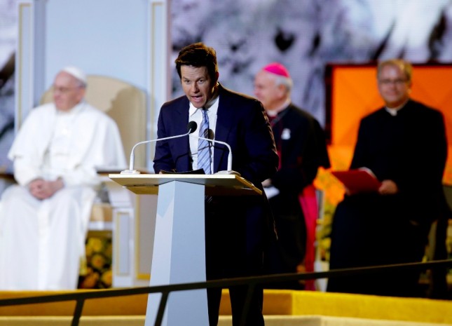 Actor Mark Wahlberg speaks as Pope Francis is seated nearby during the World Meeting of Families festival Saturday Sept. 26 2015 in Philadelphia