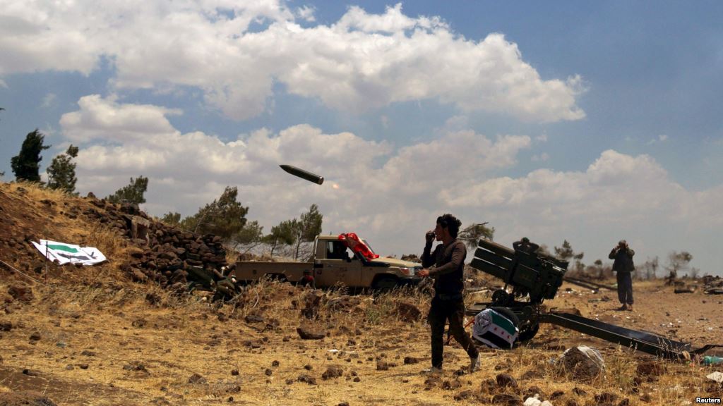 Free Syrian Army rebel fighters fire rockets towards government forces in the northern countryside of Quneitra in June this year