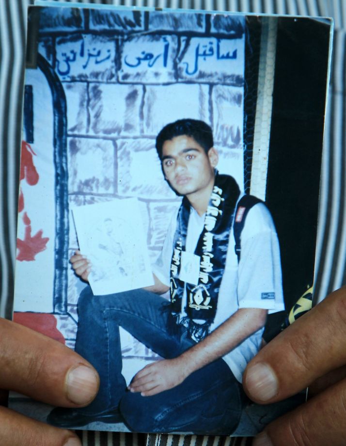 An undated portrait of Mohammed Allan is held by his father at the family home in the West Bank city of Nablus. Israel reinstated the detention without trial