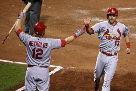 Matt Carpenter celebrates with Mark Reynolds after scoring the go-ahead run for the Cardinals in the top of the ninth inning