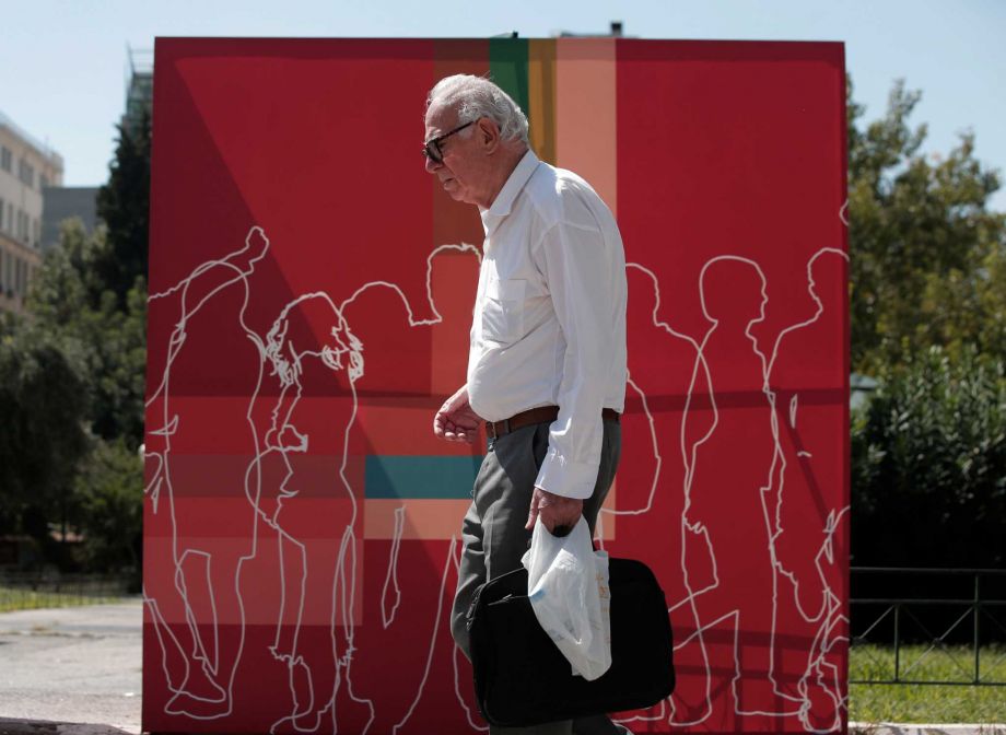 A man walks past a banner of the radical left Syriza party in central Athens Wednesday Sept. 16 2015. Greece is holding a snap general election on Sept. 20 2015. It is the third time this year Greeks will be voting with the economy still in dire str