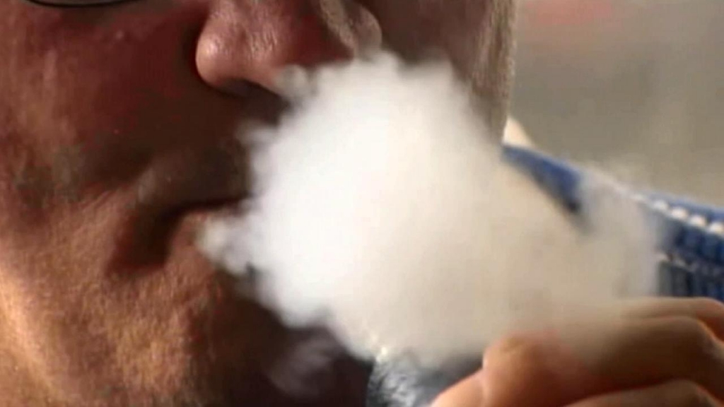 A man blows out smoke from an e-cigarette in this undated file