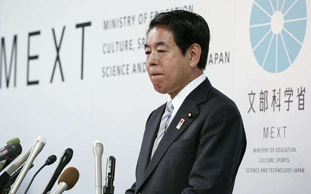 Hakubun Shimomura bites his lips during a news conference in Tokyo today