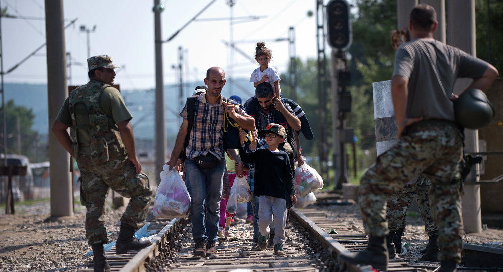 Migrants and refugees cross the Macedonian Greek border near Gevgelija