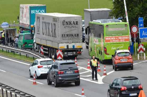 Honking cars with stressed drivers banked up for kilometres at an Austrian German road crossing