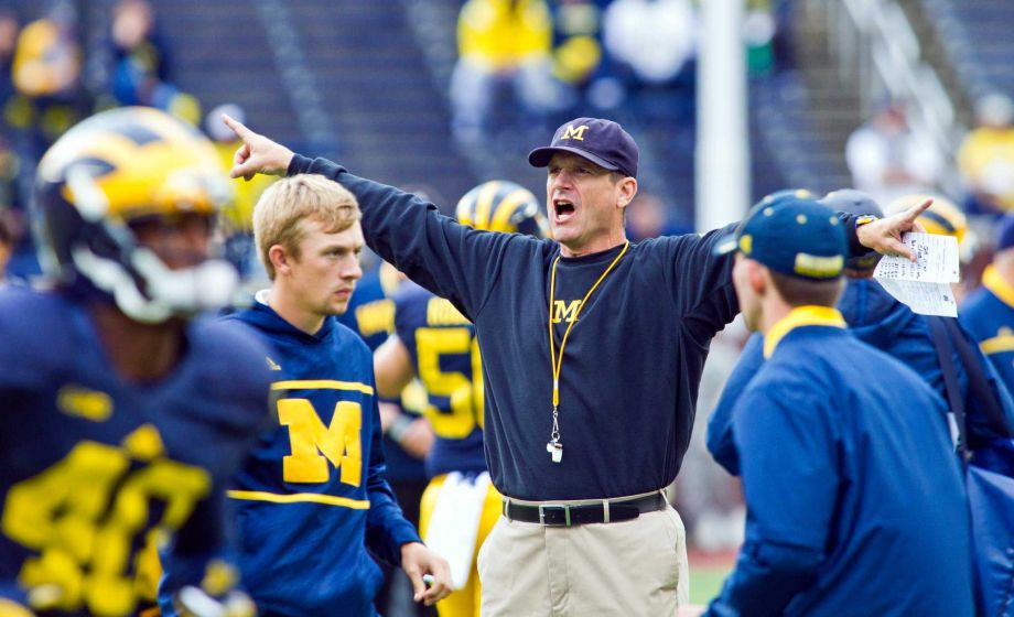 Michigan head coach Jim Harbaugh directs his players during warmups before an NCAA college football game against UNLV in Ann Arbor Mich. Saturday Sept. 19 2015