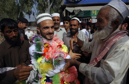 A Pakistani man center left is greeted by relatives on his arrival from Saudi Arabia after performing the Muslim hajj pilgrimage Monday Sept. 28 2015 in Peshawar Pakistan. Pakistan's minister for religious affairs says authorities have tracked